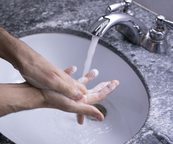 photo shows a man washing his hands