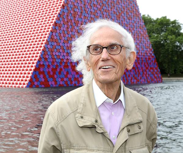 the artists standing in front of one of his works