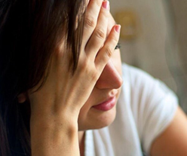 woman looking upset with head in hands