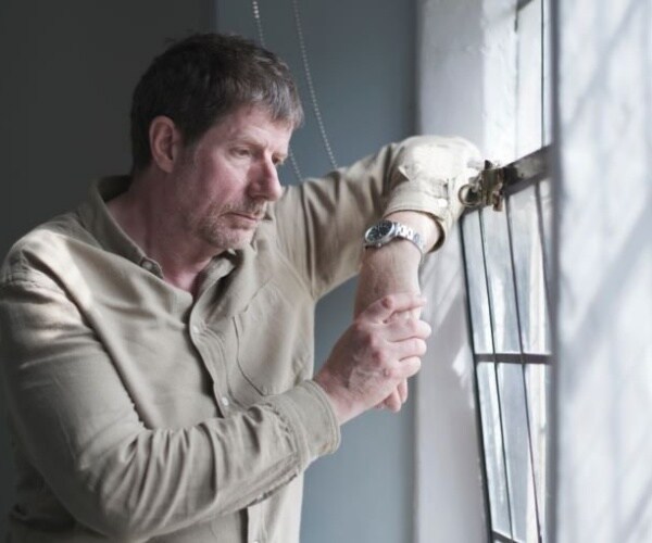 man leaning on window looking sad, lonely