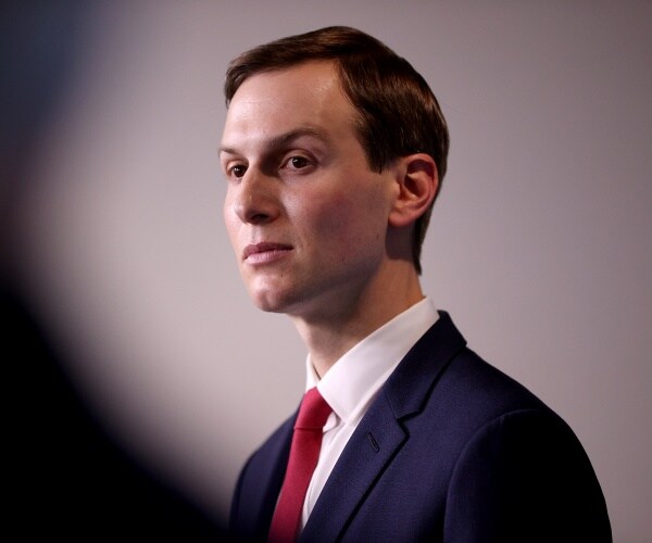 jared kushner in a suit white shirt and red tie with one eyebrow raised