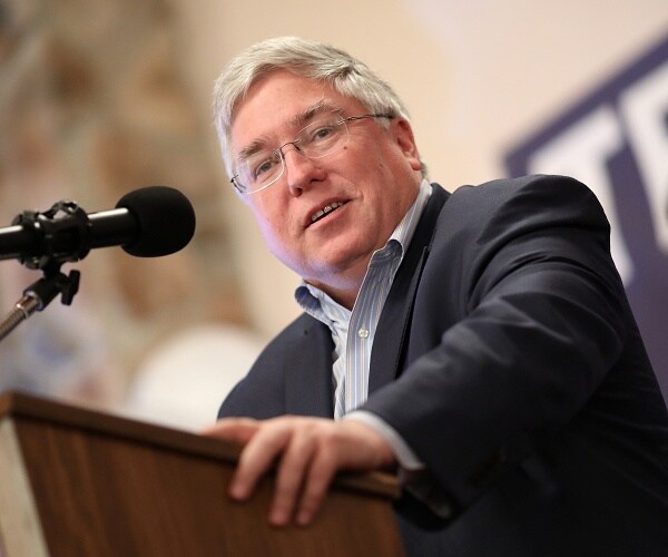 patrick morrisey leans on podium and speaks into mic