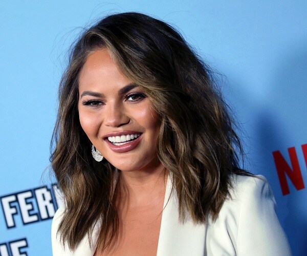 chrissy teigen stands on red carpet