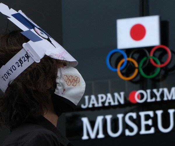 woman protests outside of japan olympic museum