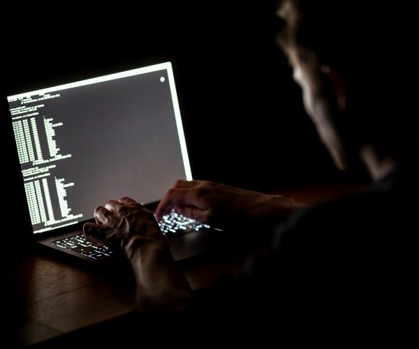 A man typing on a laptop