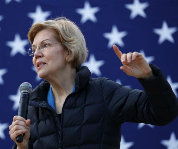 Sen. Elizabeth Warren wearing a blue bubble jacket speaks to an audience.