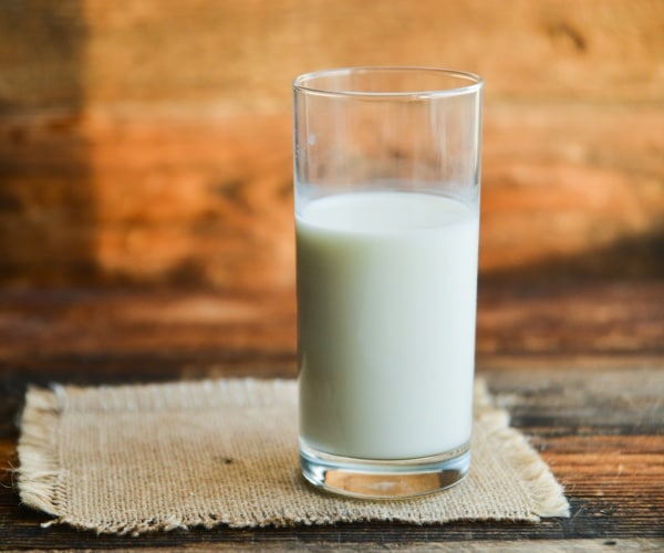 glass of milk on wooden table