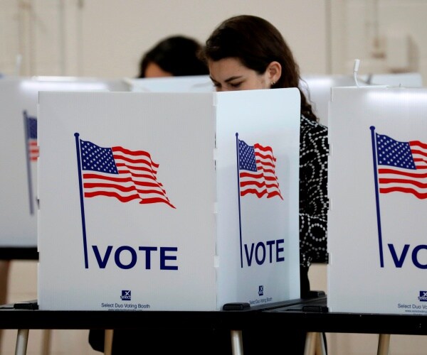 woman stands in voting booth