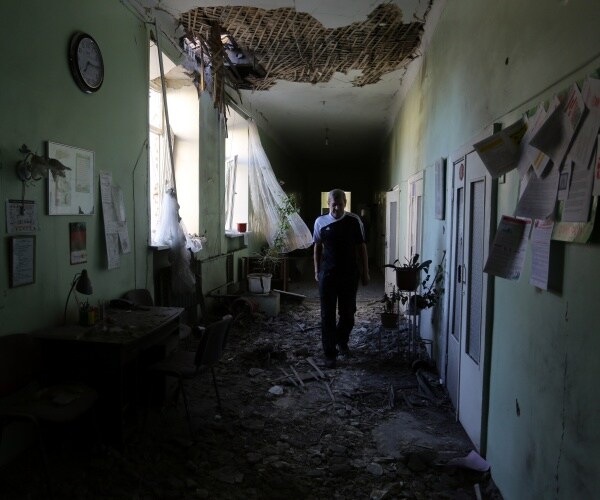 A patient walks in a hospital destroyed as a result of shelling between Ukrainian forces and pro-Russian separatists 