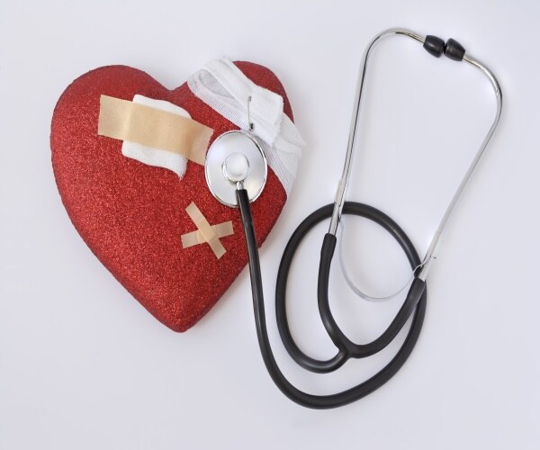 a fake heart with band-aids on it and a stethoscope next to it