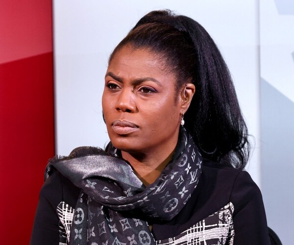 omarosa in a black and white top with a black louis vuitton scarf