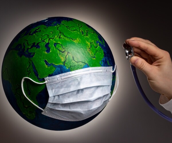 globe with a surgical mask and a hand with a stethoscope on the globe