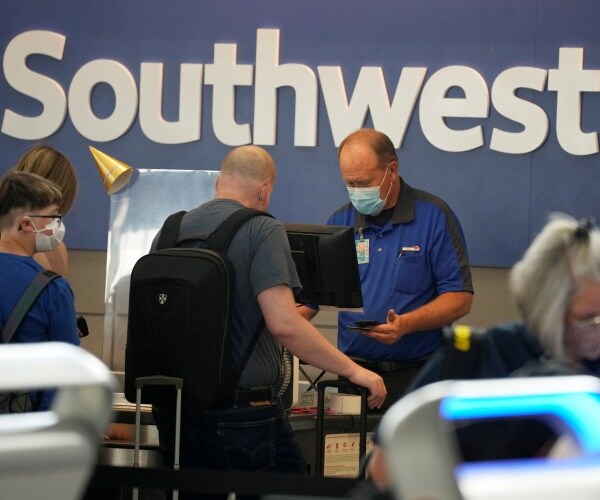 An airline ticketing agent assisting a traveler at a check-in counter