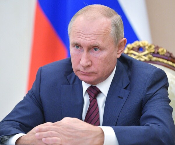 vladimir putin sits and listens during a hearing