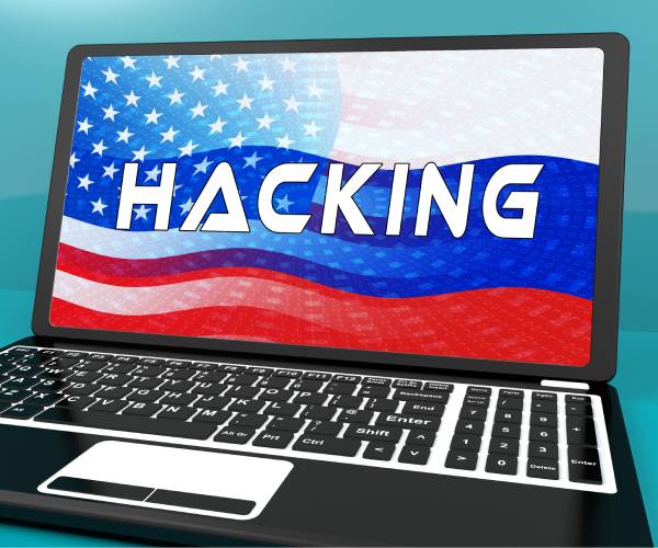 illustration of a laptop computer with the word hacking and american and russian flags on the screen