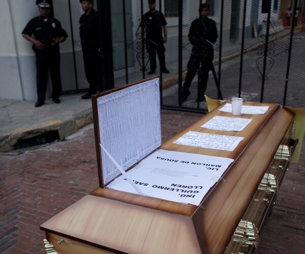 empty coffin outside gates in Panama City to represent deaths from contaminated cough syrup