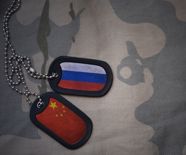 army blank dog tag with flag of russia and china on the khaki texture background