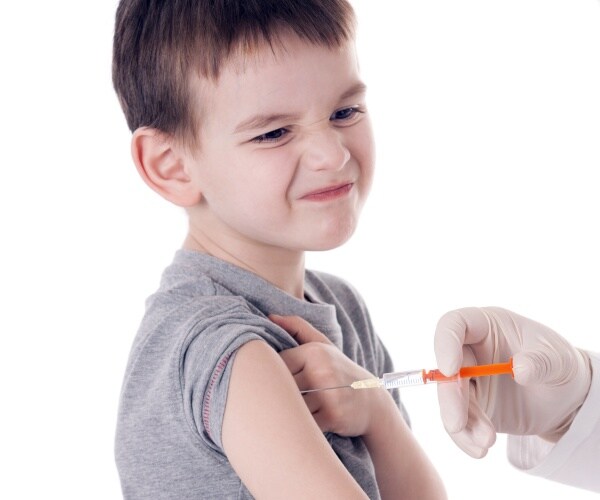 boy making a funny face while getting a vaccine