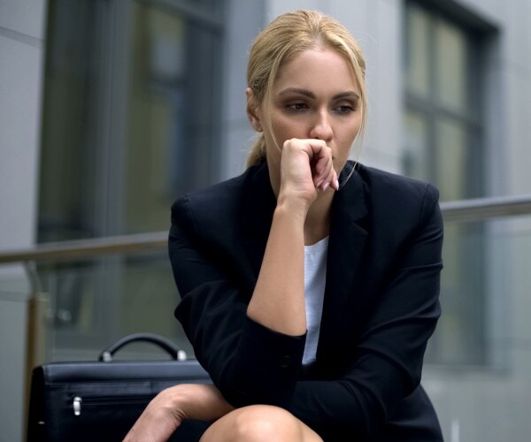 businesswoman outside in a city looking upset and depressed