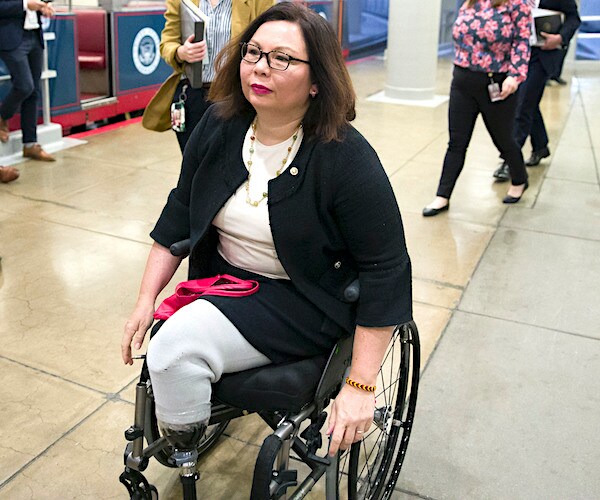 double amputee veteran tammy duckworth rides her wheelcar through the senate halls