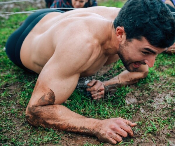 man going under wire in mud for boot camp