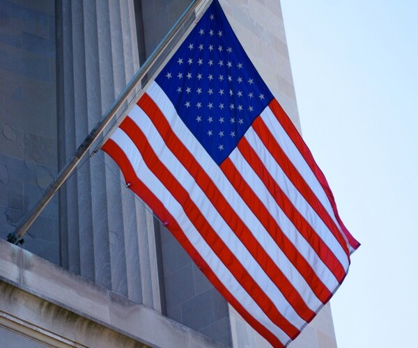 U.S flag hangs from the front of the Justice Department 

