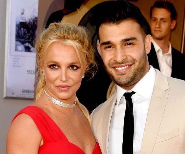 britney spears and sam ashgari stand on red carpet