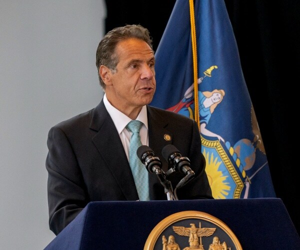 New York governor Andrew Cuomo speaking into a microphone.