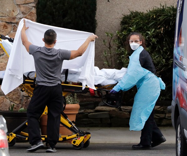 a patient is loaded into an ambulance in kirkland, washington, amid the coronavirus outbreak