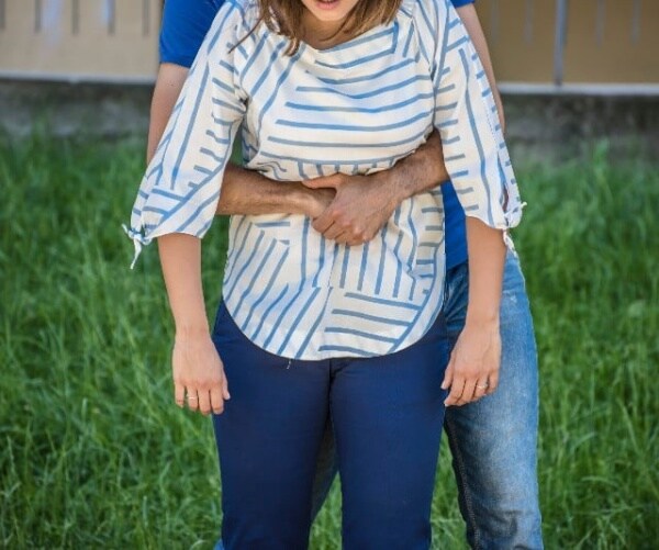 choking woman receiving the Heimlich maneuver