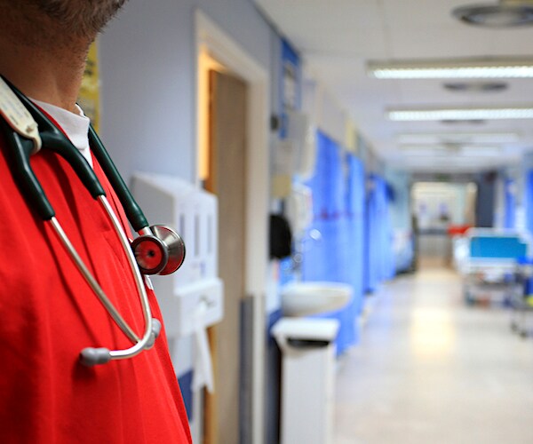 a doctor stands before a empty hospital hall