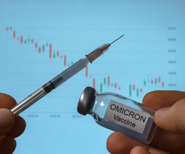 syringe and vial labeled omicron COVID vaccine with data on board in background