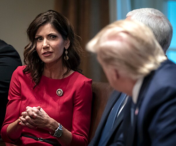 kristi noem listens to president donald trump during a white house meeting