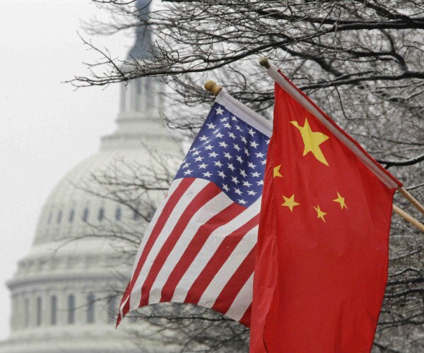 a chinese and american flag hand outside capitol dome