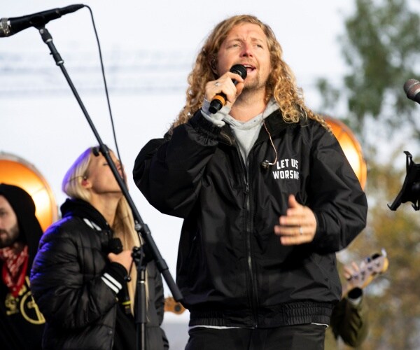 feucht sings in a black "let us worship" jacket