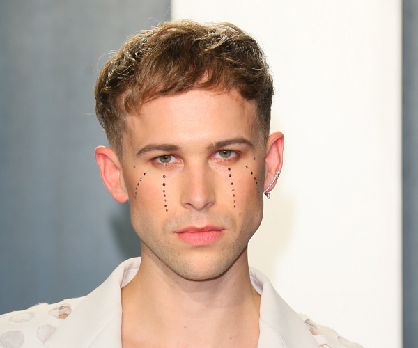 tommy dorfman stands on red carpet