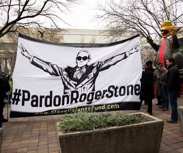 A banner calling for Roger Stone to be pardoned