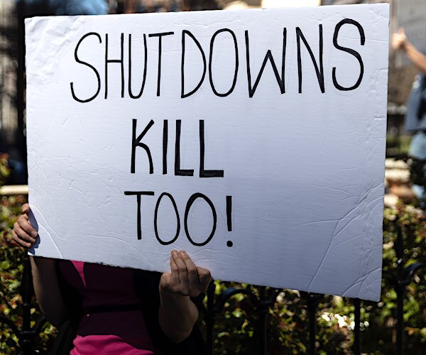 a protester holds up a sign reading shutdowns kill too