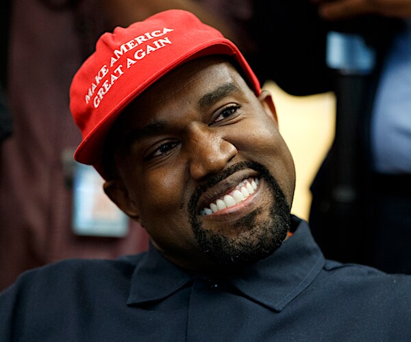 kanye west dons a smile and a make america great again hat in the oval office