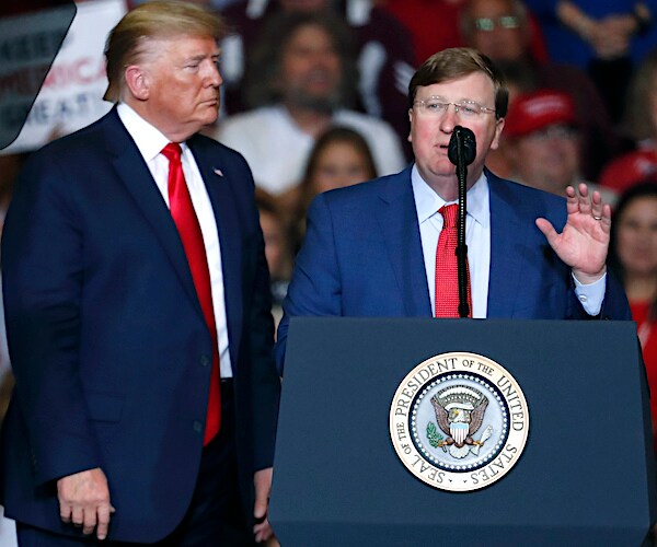 President Donald Trump listens to Lt. Gov. Tate Reeves during a Keep America Great Rally in Tupelo, Mississippi