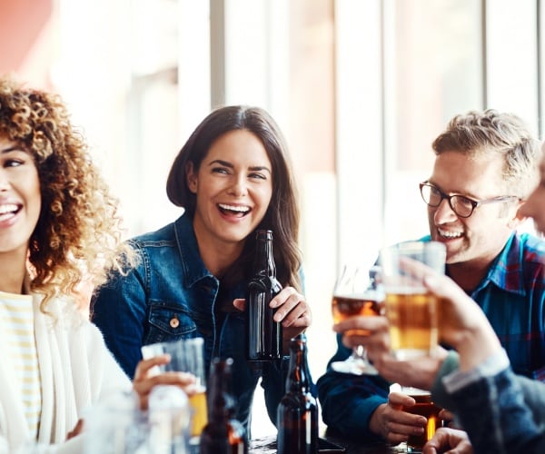 men, women out drinking drinks and smiling