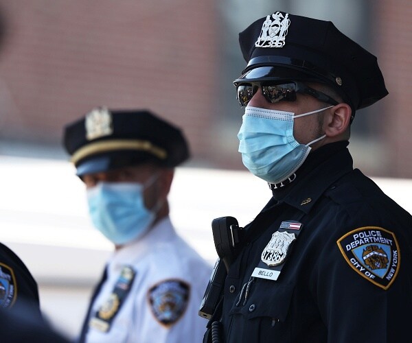 police officers stand outside wearing face masks