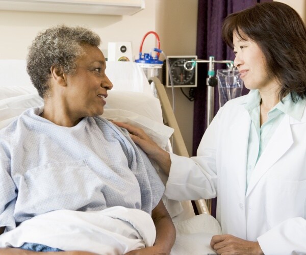 doctor talking to a woman in a hospital bed