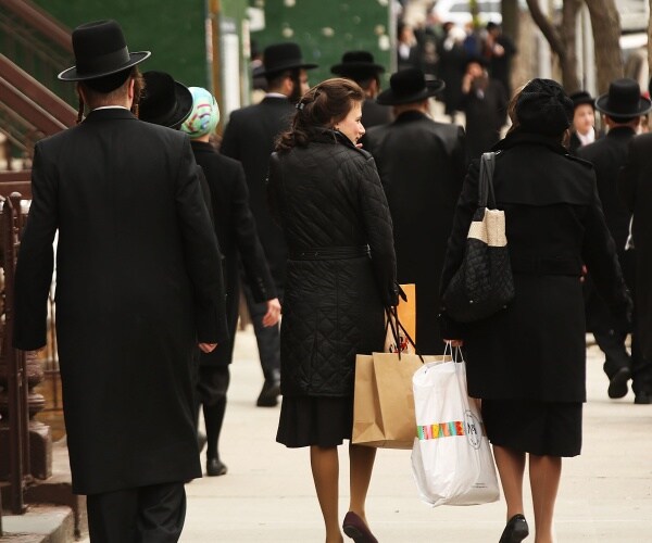 hasidic jews wearing all black walk in a jewish neighborhood in brooklyn