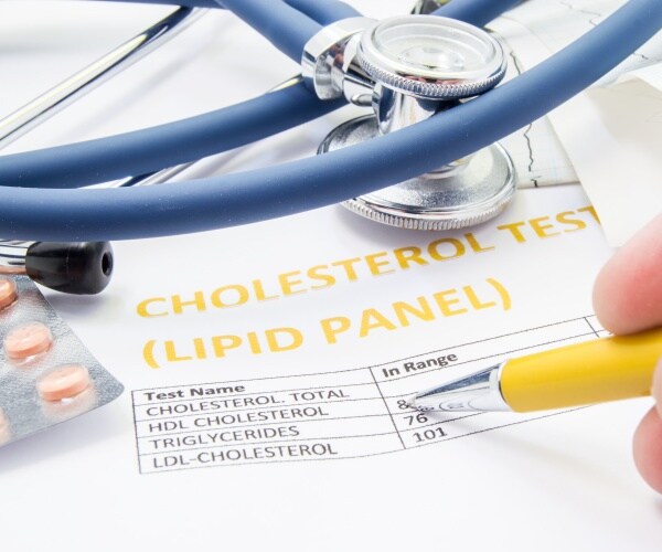 blood test results for cholesterol and triglycerides levels, stethoscope, cholesterol-lowering medication