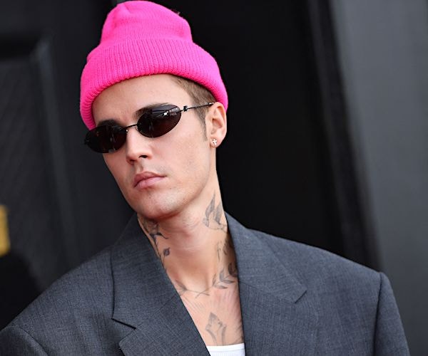 justin bieber wears a winter hat and stands contrite before the paparazzi