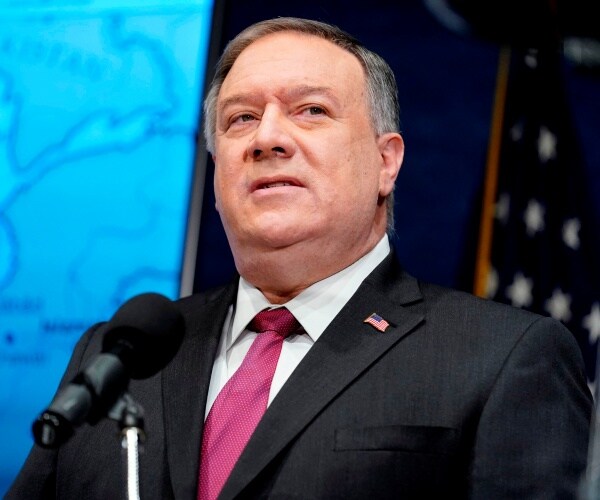 pompeo in a black suit and pink tie 