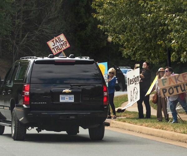 Protesters shout at President Donald Trump's motorcade