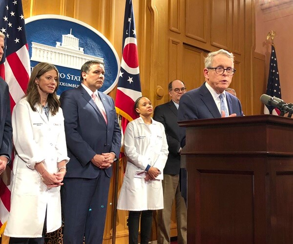 mike dewine gives a press conference with ohio state medical staff behind him