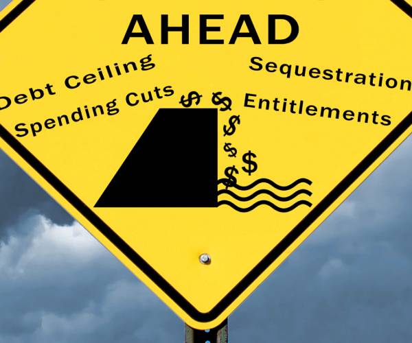 warning sign with debt ceiling spending cuts sequestration and entitlements written on it